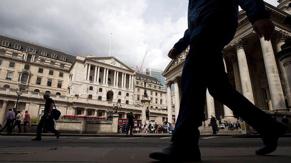 People walk past the Bank of England in central London