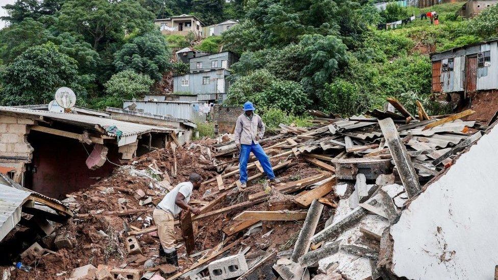 Man standing on debris in Clermont, near Durban