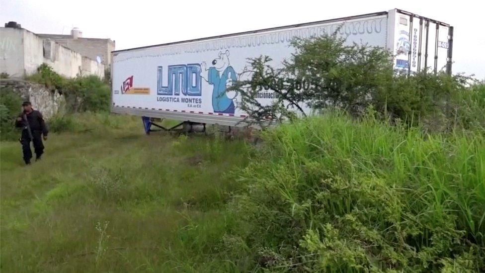 A police officer walks alongside an abandoned trailer full of bodies in Tlajomulco de Zuniga, Jalisco, 15 September 2018