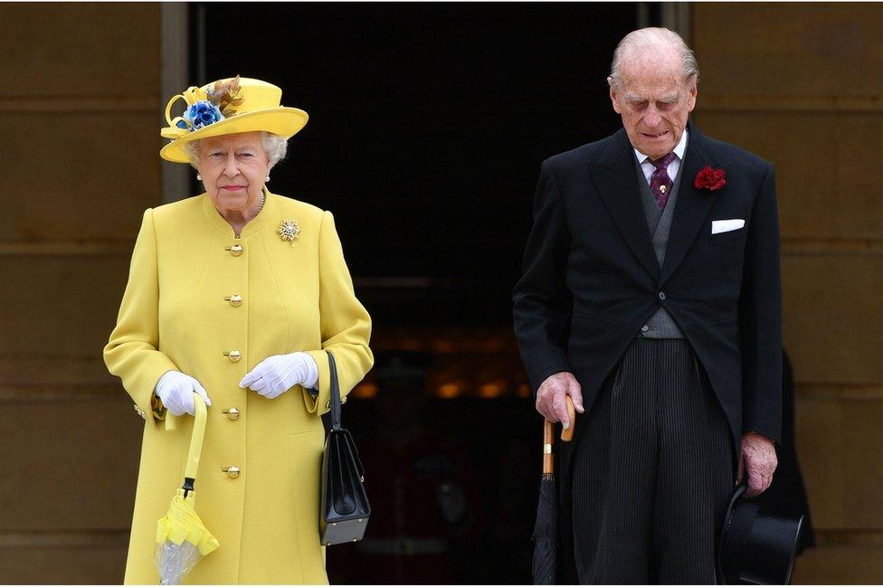 Queen Elizabeth II and the Duke of Edinburgh observing a minute's silence at the start of a garden party at Buckingham Palace in London.