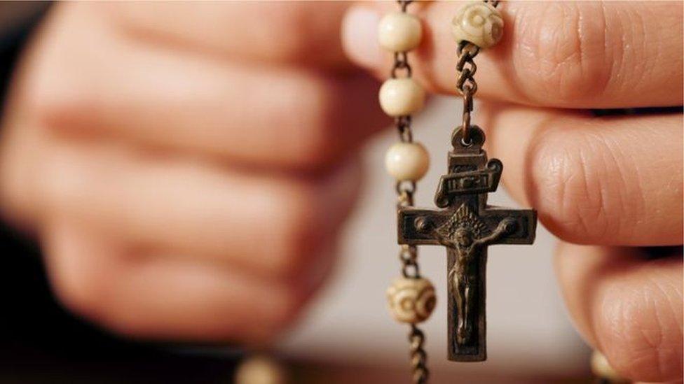 Hands holding Rosary beads