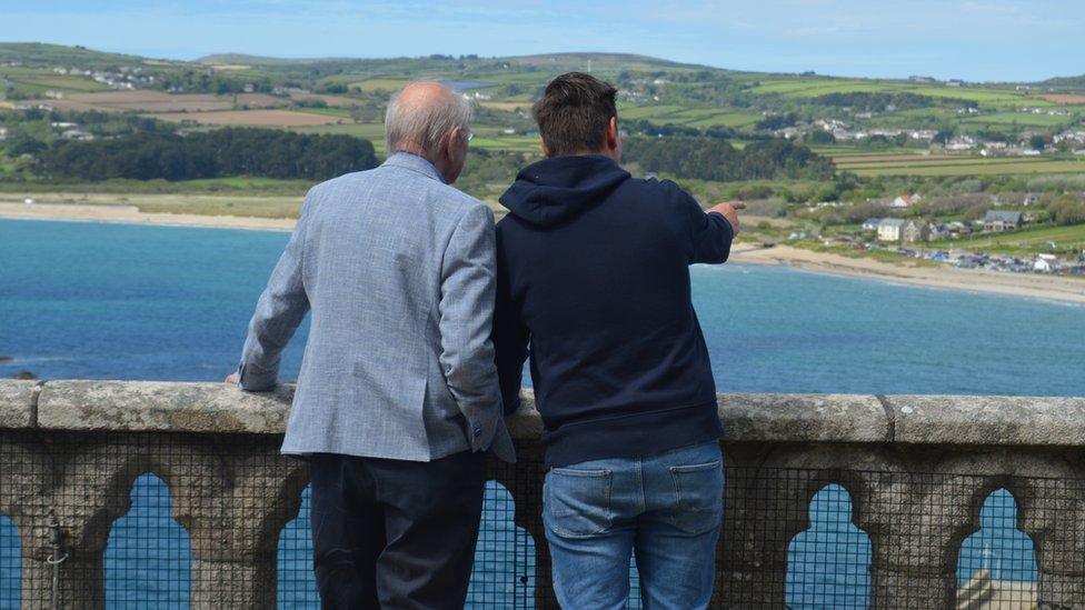 Two men enjoying view of Mount's Bay from castle in Penzance