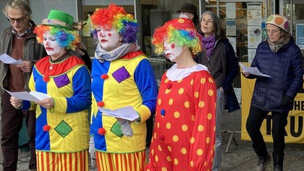 Protestors dressed as clowns