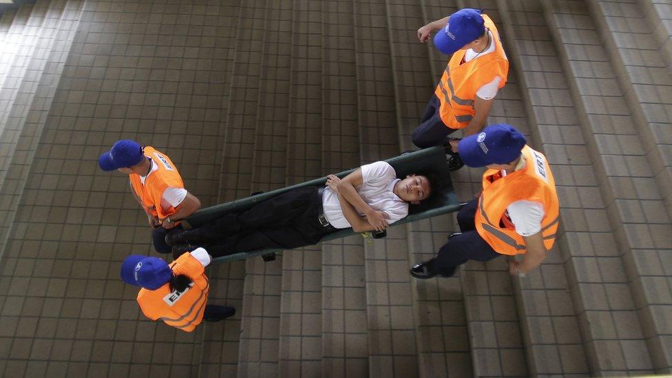 Rescuers carry a mock victim down the stairs of the Light Railway Transit, LRT, station during a Metro-wide earthquake drill to test various government agencies" response in Manila, Philippines on Wednesday, June 22, 2016.