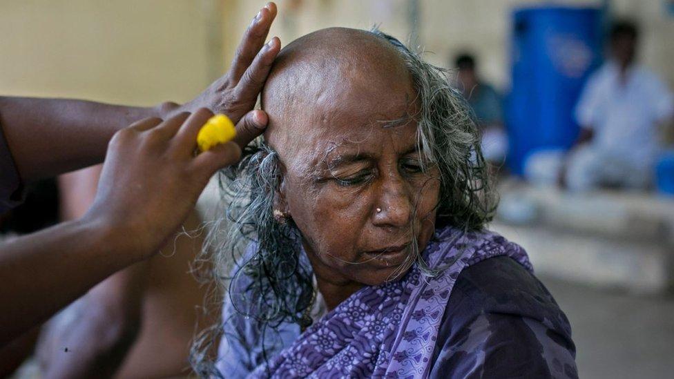 A Hindu devotee donating her hair at a temple in South India