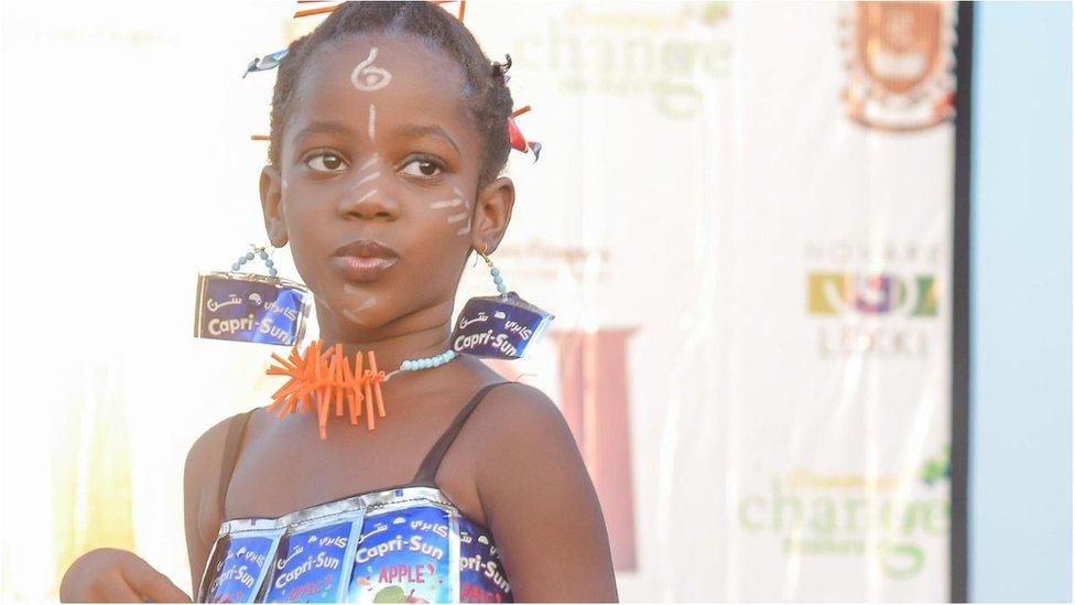 Little girl in recycled Capri-sun dress.