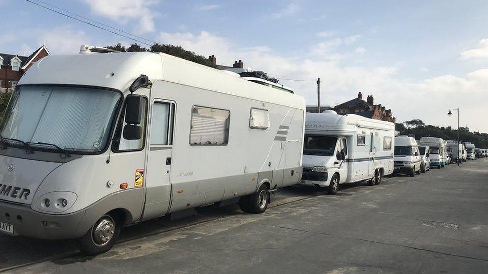 A row of motorhomes parked along the seafront