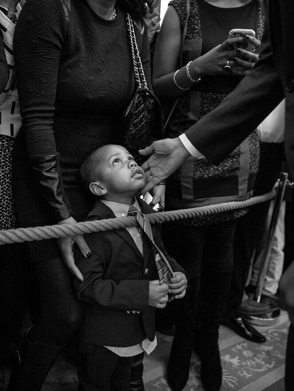 Clark Reynolds, 3, gazes up as the president touches his cheek