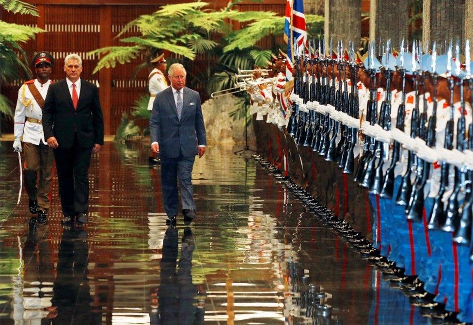 President Miguel Diaz-Canel welcomes Prince Charles walk past the guards at the Palace of the Revolution