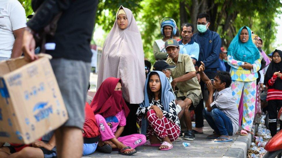 Earthquake-affected residents queue outside a government building to get relief aid in Palu in Indonesia's Central Sulawesi on October 4, 2018, after an earthquake and tsunami hit the area on September 28.