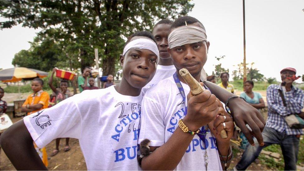 A young fighter holds a wooden gun that he hopes will be transformed into a live weapon through magic