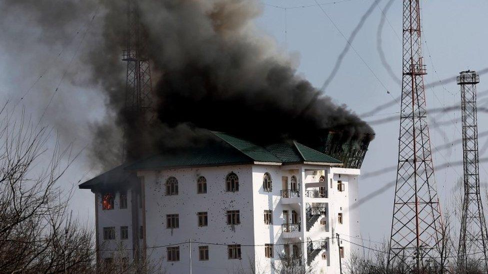 Smoke billows from a building where suspected militants have taken refuge during a gun battle on the outskirts of Srinagar (21 February 2016)