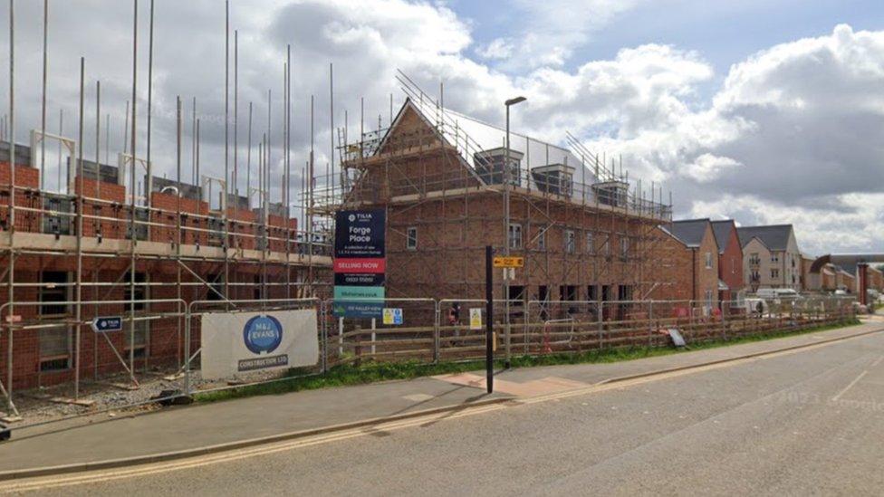 Row of modern houses, some surrounded by scaffolding