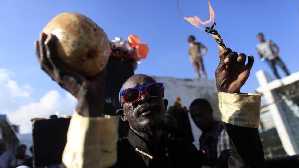 A voodoo believer participates in a ritual that pays tribute to Baron Samdi and the Gede family of spirits during Day of the Dead celebrations at the National Cemetery in Port-au-Prince, Haiti, Sunday, Nov. 1, 2015