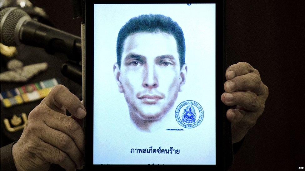 Thailand's national police spokesman Lt Gen Prawut Thavornsiri holds a tablet displaying a picture of an unnamed foreign man wanted by the police at the police headquarters in central Bangkok on Tuesday