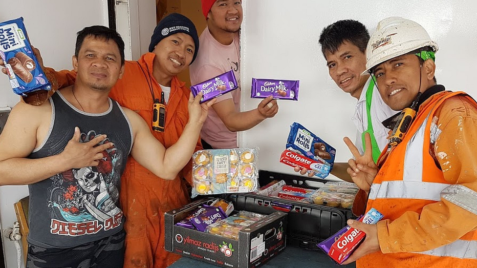 Seafarers with donated food items and toothpaste