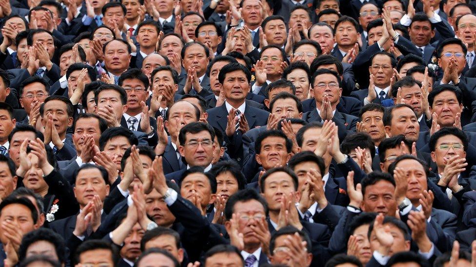 High party officials clap during a mass rally and parade