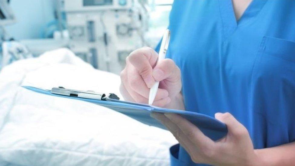 A medical staff member with a clipboard