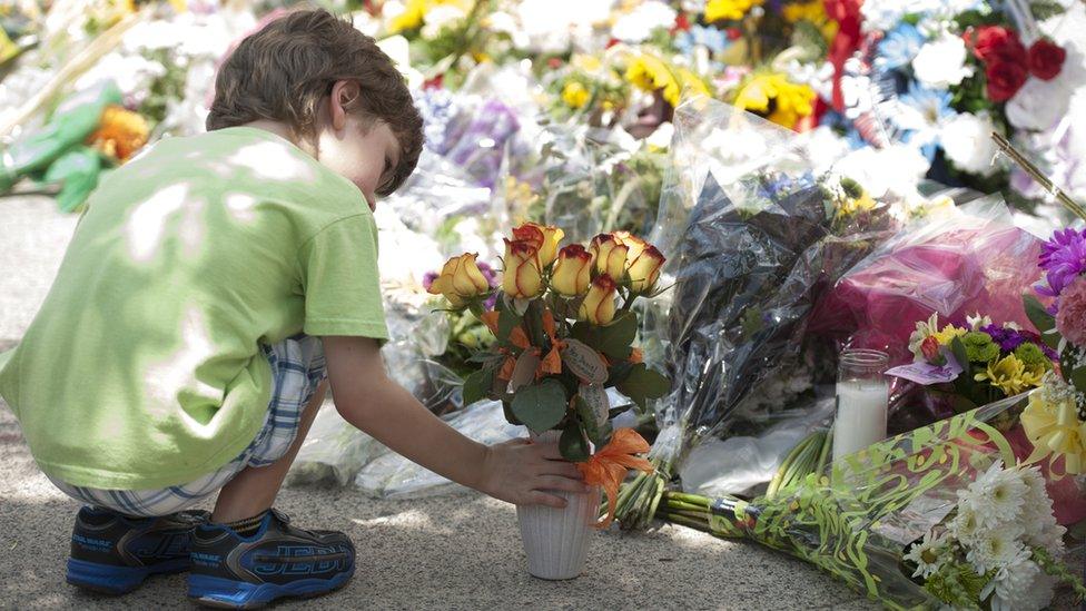 2015-06-19. A young boy left flowers in front og Emanuel AME Church in Charleston. Nine people were murdered during a bible group meeting on Wednesday. Colm O'Molloy for BBC News.