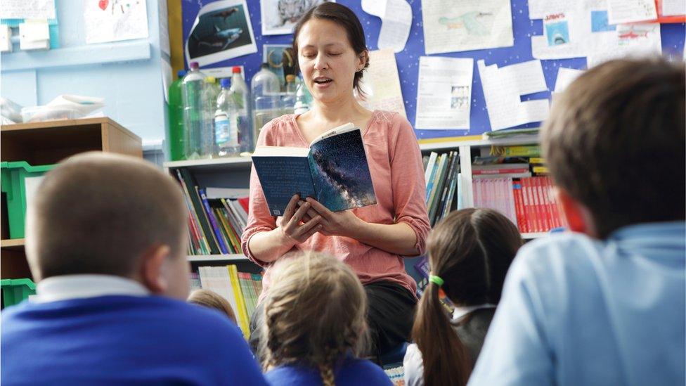 Teacher reading to pupils at a school