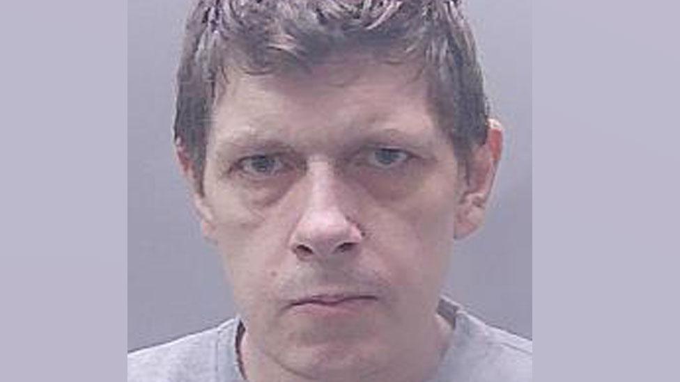 Jamie Boughen's custody image. He is staring intently at the camera