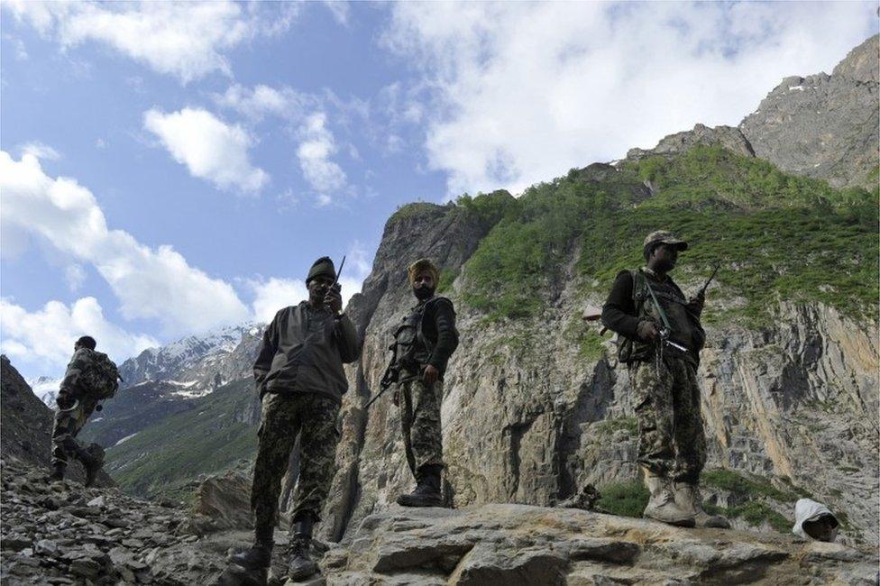 Indian Border Security Force (BSF) soldiers stand guard as Hindu pilgrims begin their annual journey from Baltal Base Camp to the holy Amarnath Cave Shrine, in Baltal