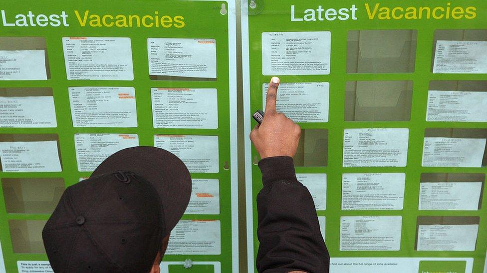 A person looks at a window showing job vacancies