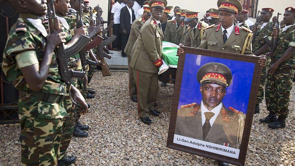 Burundian generals carry the portrait and the coffin of General Adolphe Nshimirimana from the morgue for his funeral