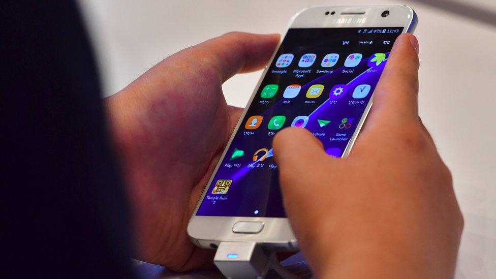 A man tests a Samsung Galaxy S7 at its showroom in Seoul