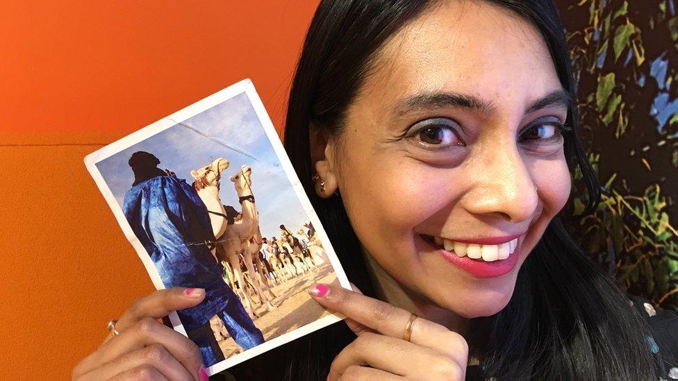 Dhruti holding a postcard