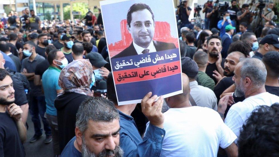 Hezbollah and Amal supporters hold a poster of Judge Bitar - 14 October