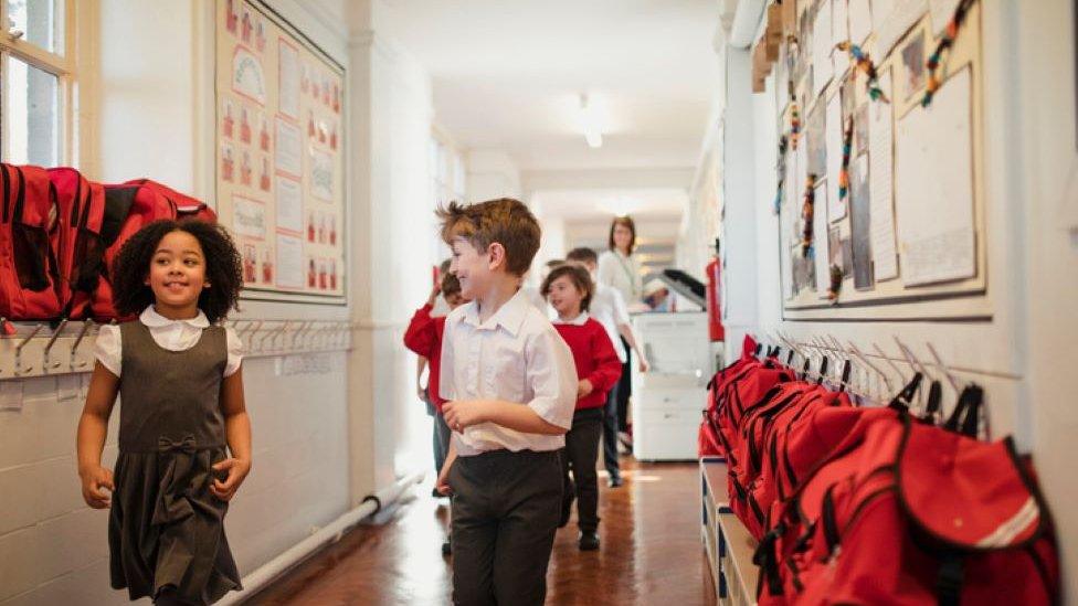 Children running down a school corridor