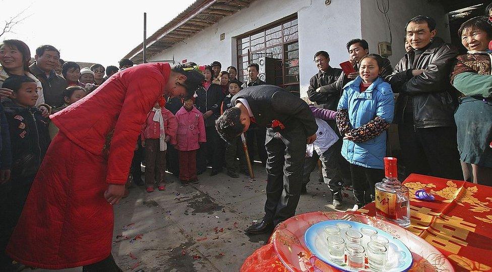 A Chinese groom and bride bow to each other during a wedding ceremony on 19 January 2006 in Linze County of Gansu Province, northwest China