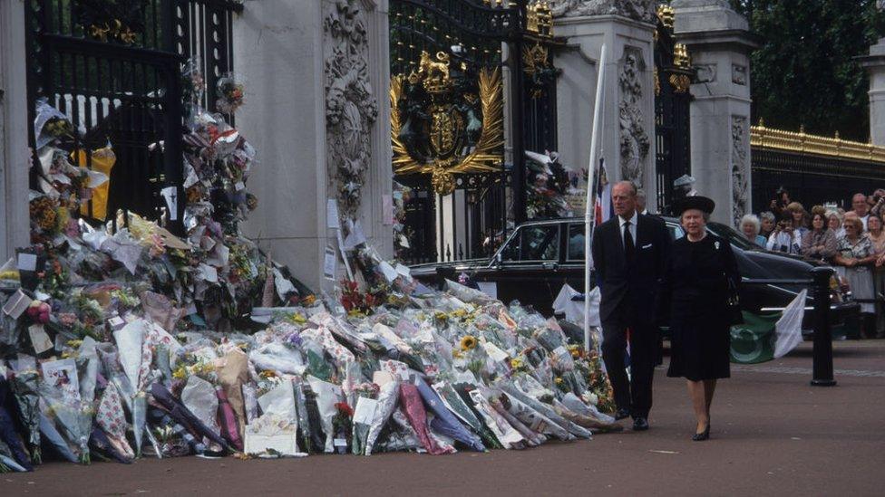 The Queen and her husband Prince Phillip The Duke of Edinburgh look at flowers left outside of Buckingham Palace following the death of Princess Diana.