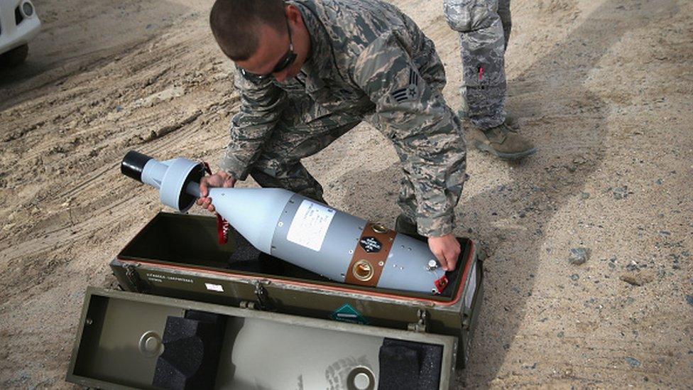 US Air Force munitions team member uncases the laser-guided tip for a 500 pound bomb to be loaded onto an unmanned aerial vehicle for airstrikes on IS targets