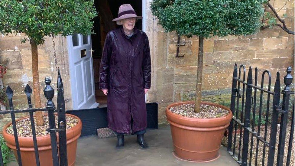 A woman in a raincoat blocking flood water