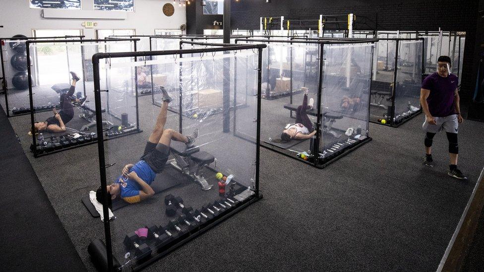 Peet (R) trains his students surrounded by plastic sheets to ensure social distancing at the Inspire South Bay Fitness gym amid the coronavirus pandemic in Redondo Beach, California