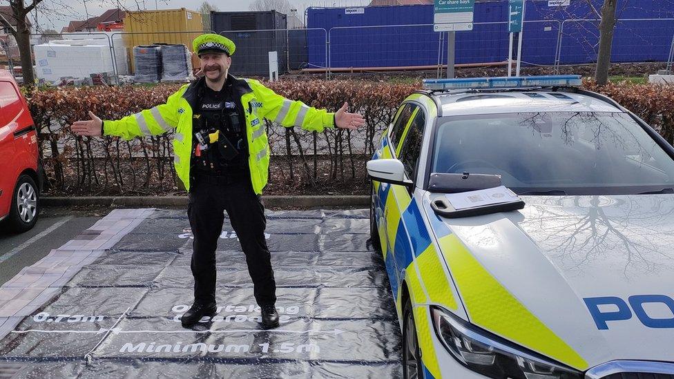 A police officer demonstrates the gap vehicles should leave