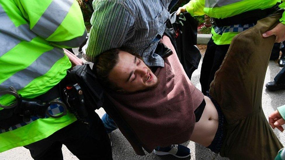 Protester Conor being arrested at Theresa May's manifesto speech