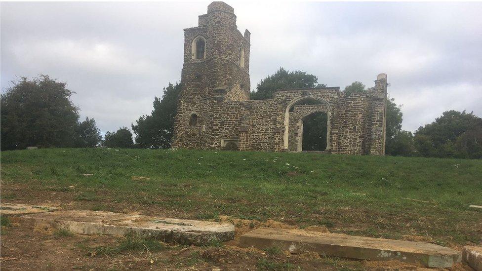 Remains of church and gravestones on ground