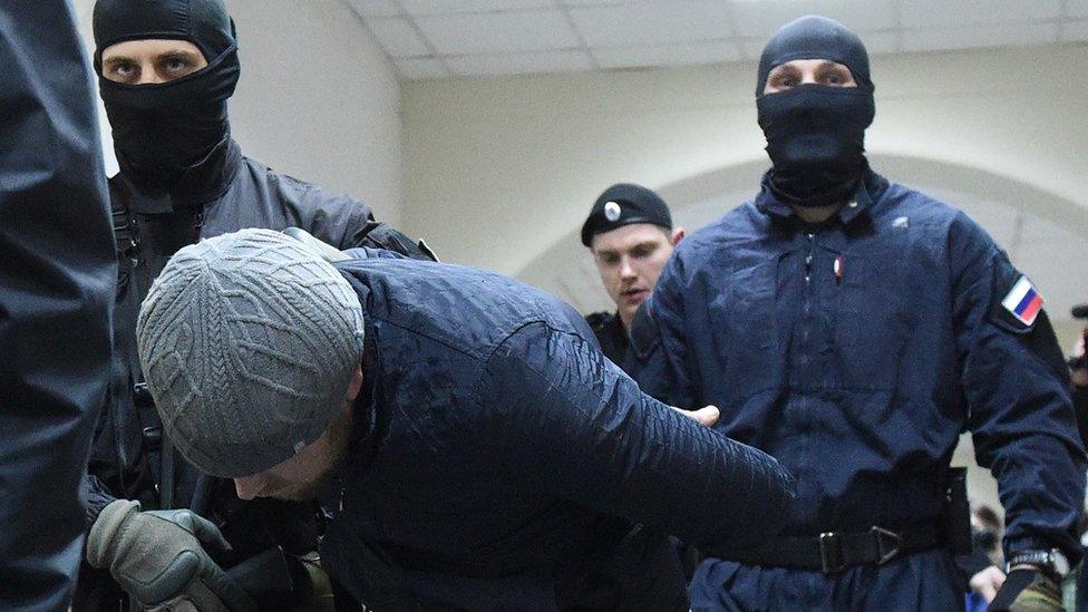 Russian police escorting one of the Nemtsov murder suspects, 8 Mar 15