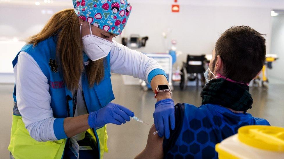 A police officer is vaccinated with AstraZeneca vaccine against Covid-19, 25 February 2021