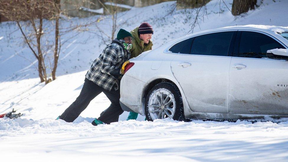 East Austin residents push a car out of the snow on February 15, 2021 in Austin, Texas.