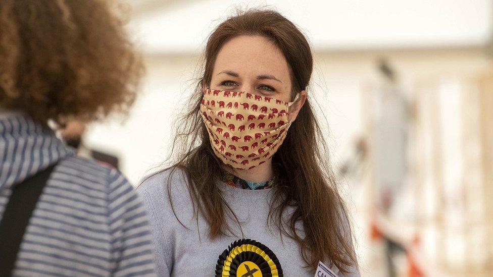 The SNP's Kate Forbes speaks to a woman at a count in Aberdeen, wearing a face mask decorated with elephants