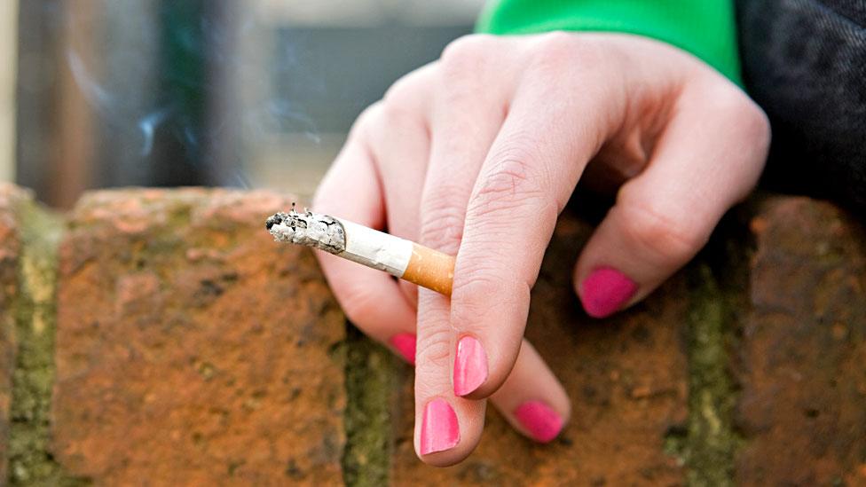 A hand holding a cigarette