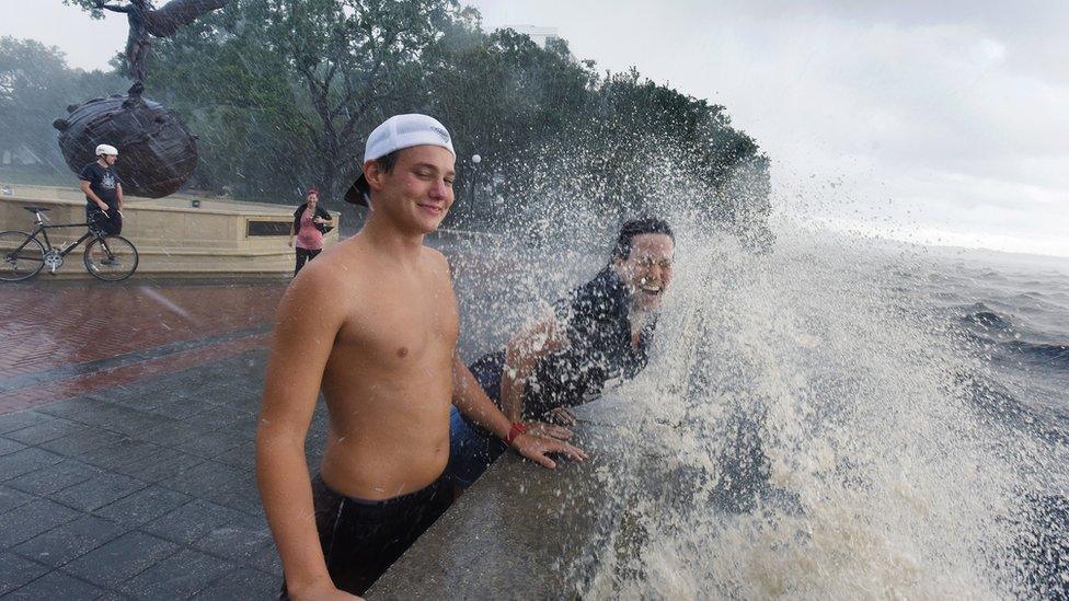 Connor Sidman and his mother Peggy Sidman get hit by a wave, as they take in the sights from the railing of Memorial Park in Jacksonville, Florida, Friday, 2 September 2016.