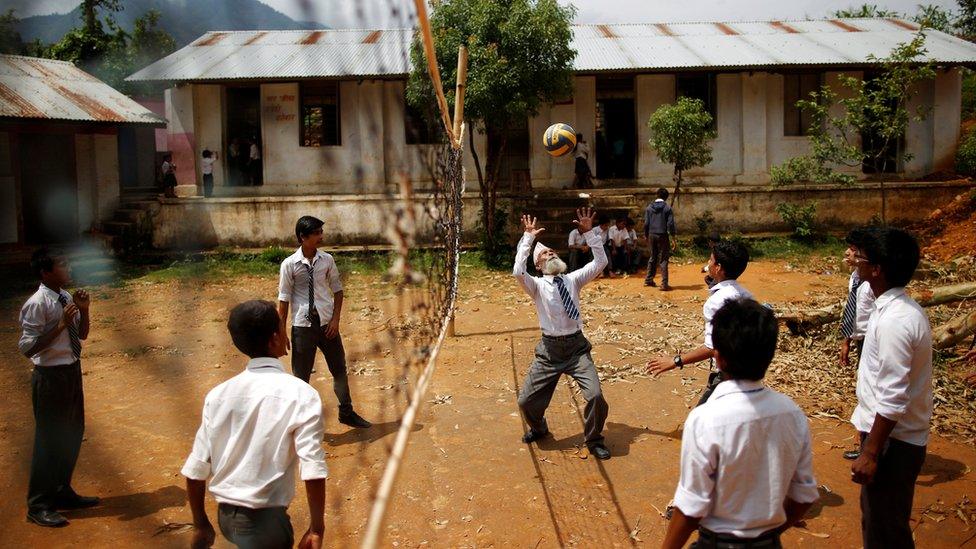 Mr Kami plays volleyball with friends during a break