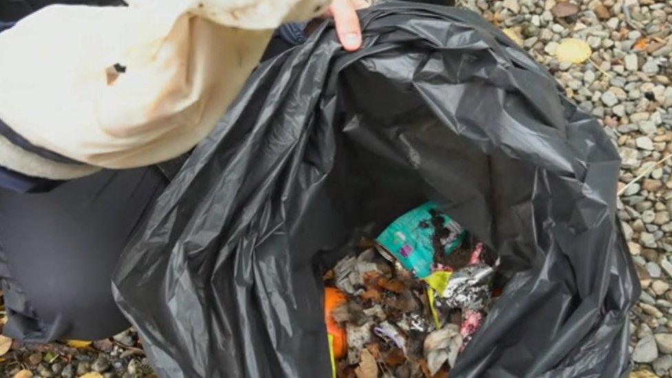 Black refuse bag full of rubbish from the island