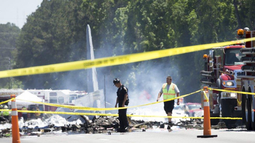 The tail of a military C-130 plane sticks up from the road as emergency crews work at the site of the crash in Georgia, USA, 2 May 2018