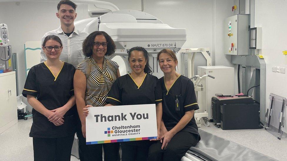 Hospital staff with a than you sign standing in front of the scanner